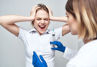 Patient screaming while doctor holding syringe