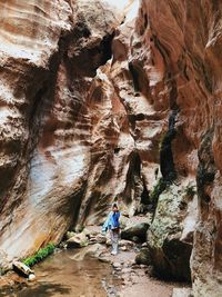 Rear view of man surfing in cave