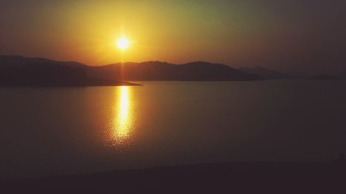 Lake with mountain and sun during sunset