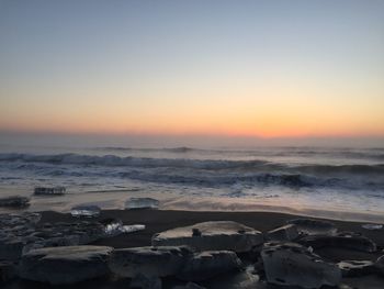 Scenic view of sea against clear sky during sunset