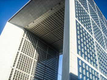 Low angle view of modern building against blue sky