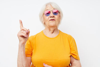 Portrait of young woman gesturing against white background