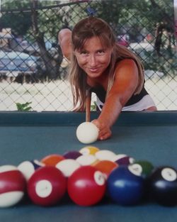 Midsection of woman playing pool