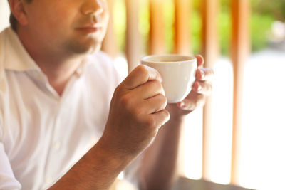 Close-up of man holding coffee cup