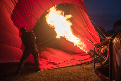 Man preparing hot air balloon at night