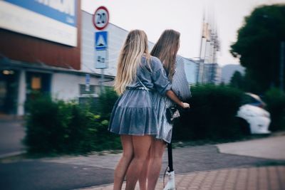 Rear view of women walking on street in city