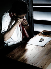 Man looking at amulet through loupe