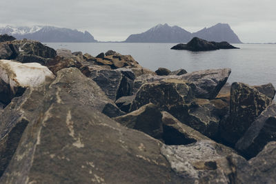 Rocks on sea shore against sky