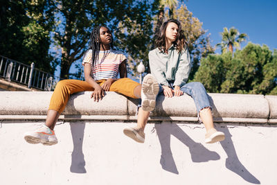 Full length of women sitting at park