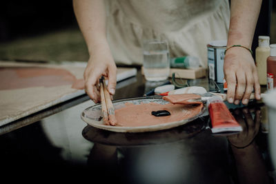 Midsection of woman preparing food on table