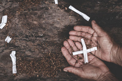 Cropped hands holding cigarettes outdoors