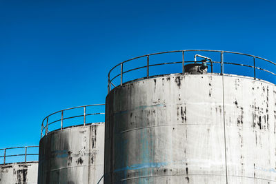 Low angle view of factory against clear blue sky