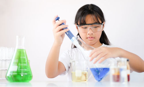 Girl doing experiment against white background