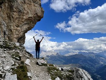 Rear view of woman standing on mountain against sky