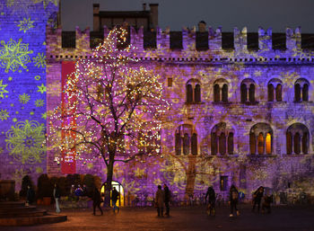 People on illuminated building at night