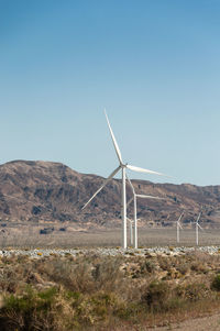 Windmill on field against clear sky