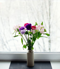 A bright delicate bouquet of flowers on the background of a white winter window. high quality photo.