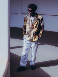 Portrait of young man standing against wall