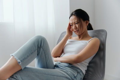 Young woman sitting on sofa at home