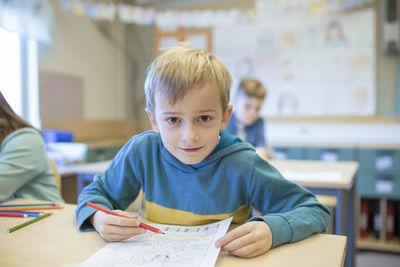 Portrait of boy sitting on table