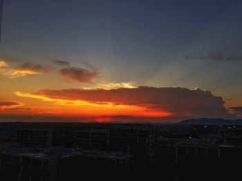 Silhouette cityscape against sky during sunset