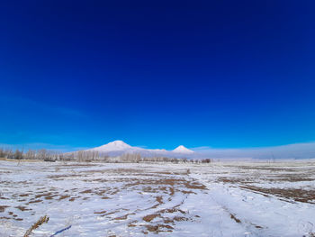 Scenic view of snowcapped mountains against blue sky