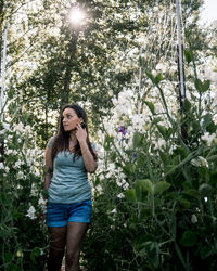 Woman standing amidst white flowers at park