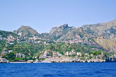 Panoramic shot of townscape by sea against clear sky