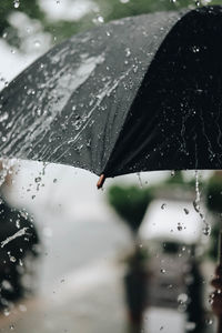 Close-up of black umbrella during rainfall