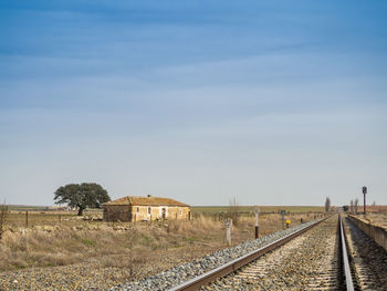 Railroad tracks on field against sky