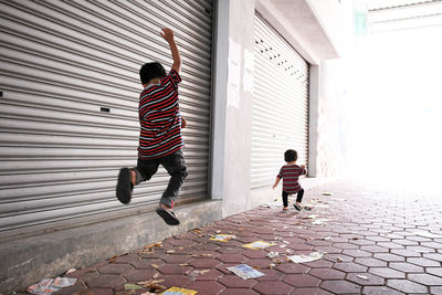 Siblings walking on footpath