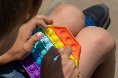 Popit toy in hands of playing boy. closeup.