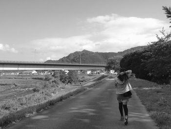 Full length of woman standing on mountain against sky