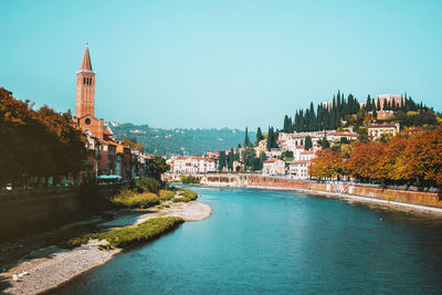 Sunny day in old city verona, italy. the adige river embankment, tower and castle on the hill.