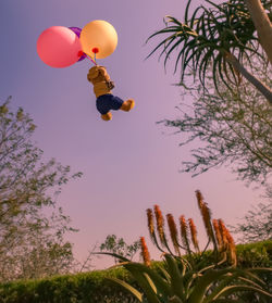 Low angle view of balloons flying against sky