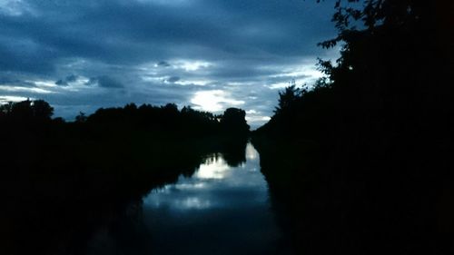 Scenic view of river against cloudy sky