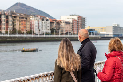 Rear view of people in boat in city