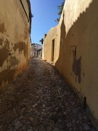 Alley amidst buildings against clear sky