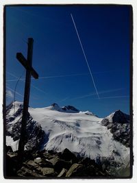 Snow covered landscape against blue sky