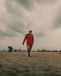 Rear view of man walking on beach