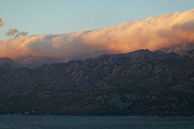 Scenic view of clouds above velebit  mountains against sky during sunset