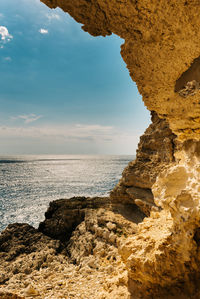 Rock formation on beach against sky