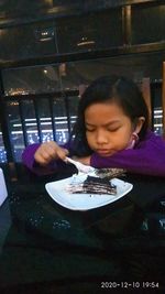 Girl holding ice cream in restaurant