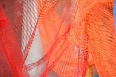 Full frame shot of orange and red fishing net