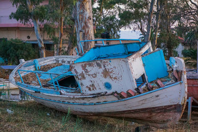 Abandoned obsolete old boat on shore