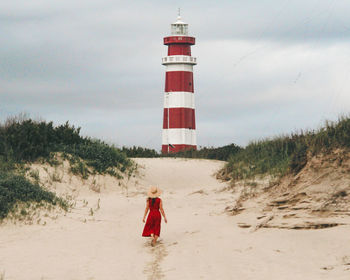 Lighthouse by sea against sky