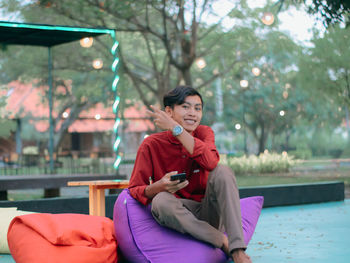 Young woman using mobile phone while sitting in gym