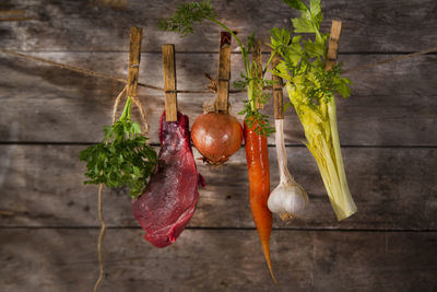 Close-up of meat with vegetables hanging on rope