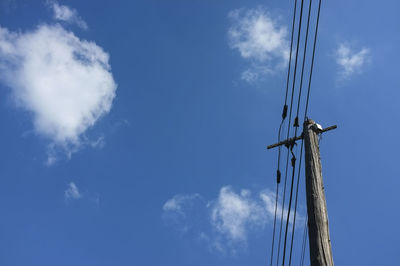 Low angle view of windmill against blue sky