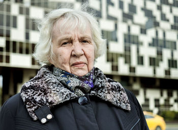Portrait of senior woman standing in city during winter